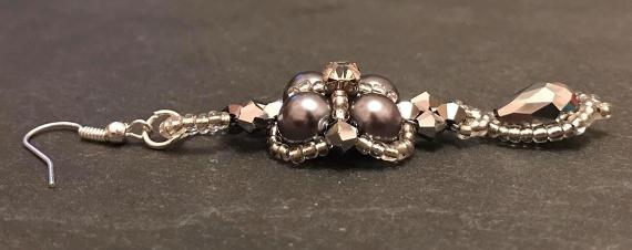 Side view of the thundercloud earring made from grey pearls and silver seeds and crystals.