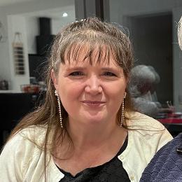 A photo of me wearing a cream cardigan and sparkly earrings.