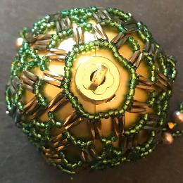 Top view of Arabian Nights bauble made with green seed beads and bronze twisted bugle beads.