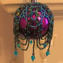 Arabian Nights Christmas tree bauble ornament decoration. Turquoise seed beads and purple metallic rainbow twisted bugle beads on a purple glass ball.