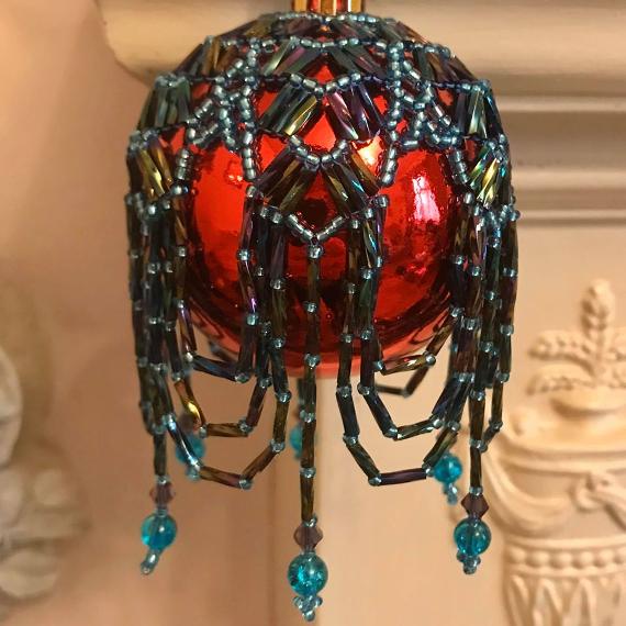 Arabian nights bauble made with turquoise seed beads and purple metallic rainbow twisted bugle beads on a shiny red bauble.