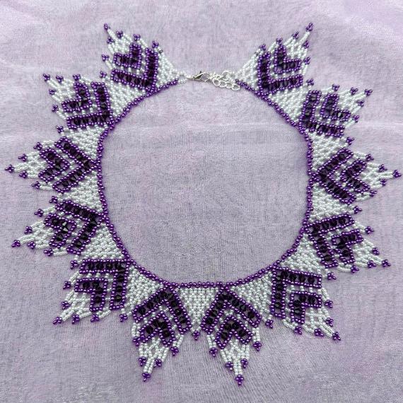A lace collar necklace made from pearls and seed beads.