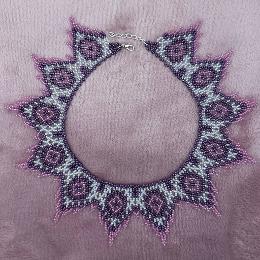 A photo of a lace necklace made from seed beads.