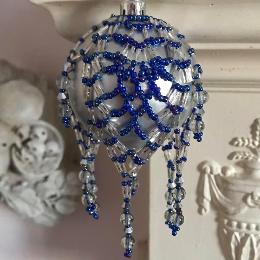 Christmas decoration made form blue and silver beads on a matt silver bauble tree ornament.