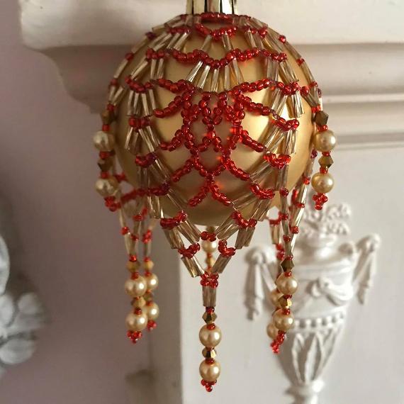Red and gold pineapple bauble cover on a matt gold glass bauble ornament.