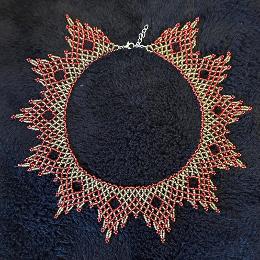 A photo of a lace necklace made from seed beads.