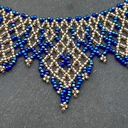 A photo of a lace necklace made from seed beads.