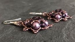 Side view of silver squares earrings made with purple pearls and crystals.
