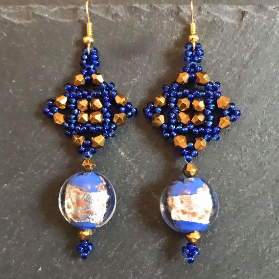 Tudor Square earrings made from dark blue seed beads, gold metallic bicone crystals and a blue coin glass bead with silver foil.