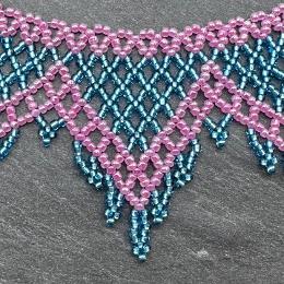 A photo of a lace necklace made from seed beads.