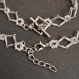 A close up photo of a toggle claps and a lobster clasp on a beaded bracelet.