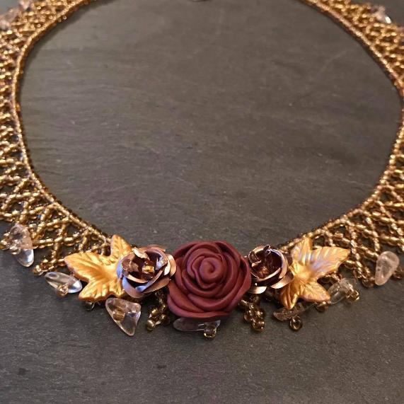 Flower net necklace made with gold beads and featuring a brown polymer clay rose.