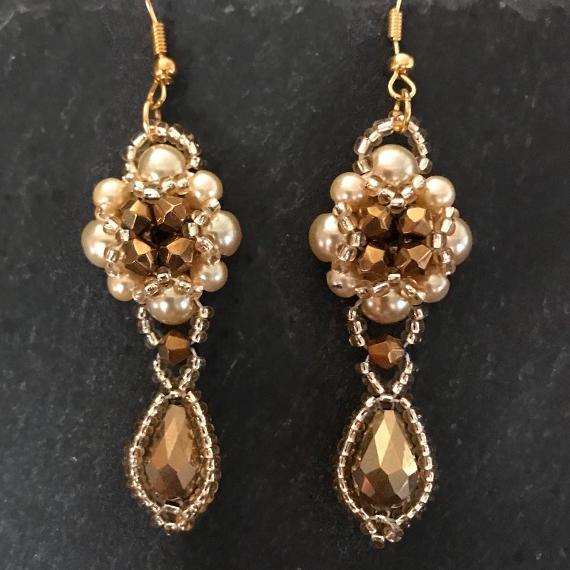 Hulton Abbey earrings made from two sizes of gold pearls with gold metallic crystals.