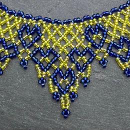 A photo of a lace necklace made from seed beads.