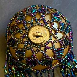 Shirley bauble. Metallic rainbow beads on a gold ball Christmas tree ornament.