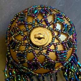 Shirley bauble. Metallic rainbow beads on a gold ball Christmas tree ornament.