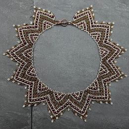 A photo of a lace necklace made from seed beads.