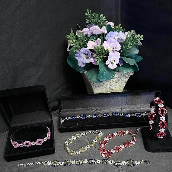Six bracelets with a pot of purple flowers.