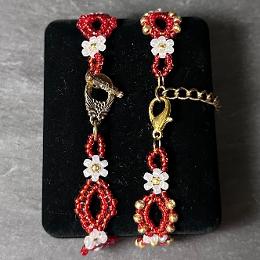 A close up view of a toggle clasp and a lobster clasp on two red bracelets.