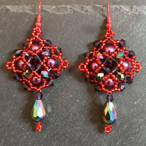 Persephone earrings made in shades of red and blue so they look like a pomegranate.
