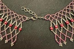 A close up photo of a lace necklace made from brown seed beads.