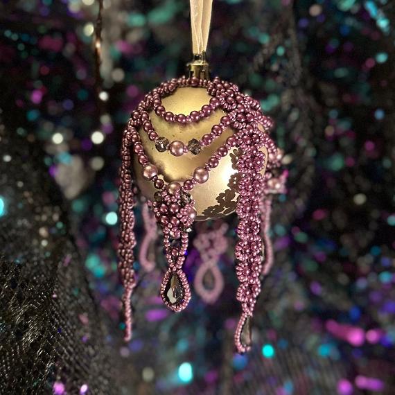Purple bauble on a glittery background.