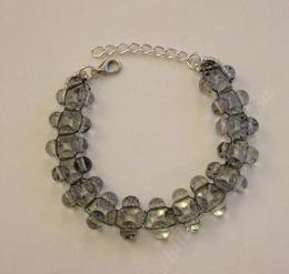 Round glass bead right angle weave bracelet lying on a white surface.