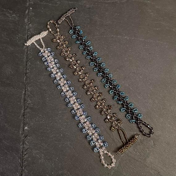Three bracelets made from crystals and seed beads each with a beaded toggle clasp.