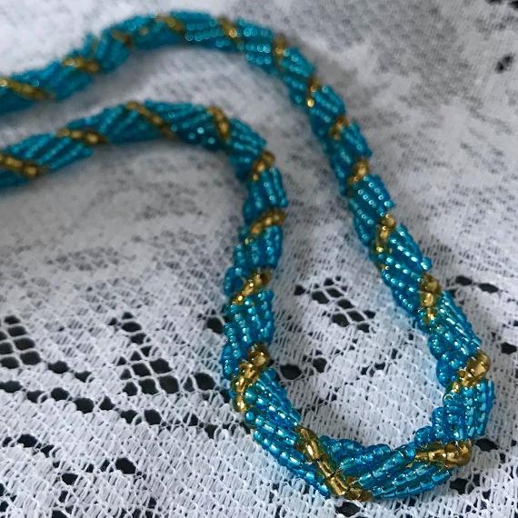 Turquoise spiral rope on a white lace background.