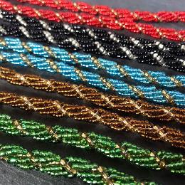 Spiral ropes in five different colours lying diagonally in double rows on a grey slate.