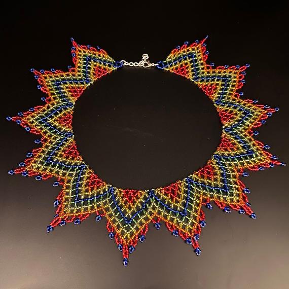 A photo of a lace collar necklace on a velvet stand with a white lace background.