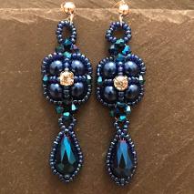 Thundercloud earrings made from royal blue pearls with blue seed beads, a diamante rhinestone, and blue metallic bicones and teardrop crystals.