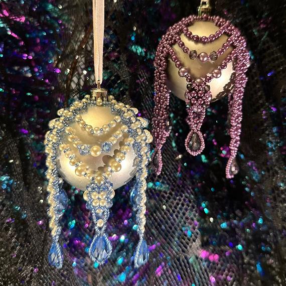 Two beaded baubles on a glittery background.